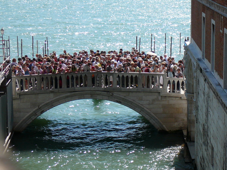 Толпа туристов фотографирует мост Вздохов